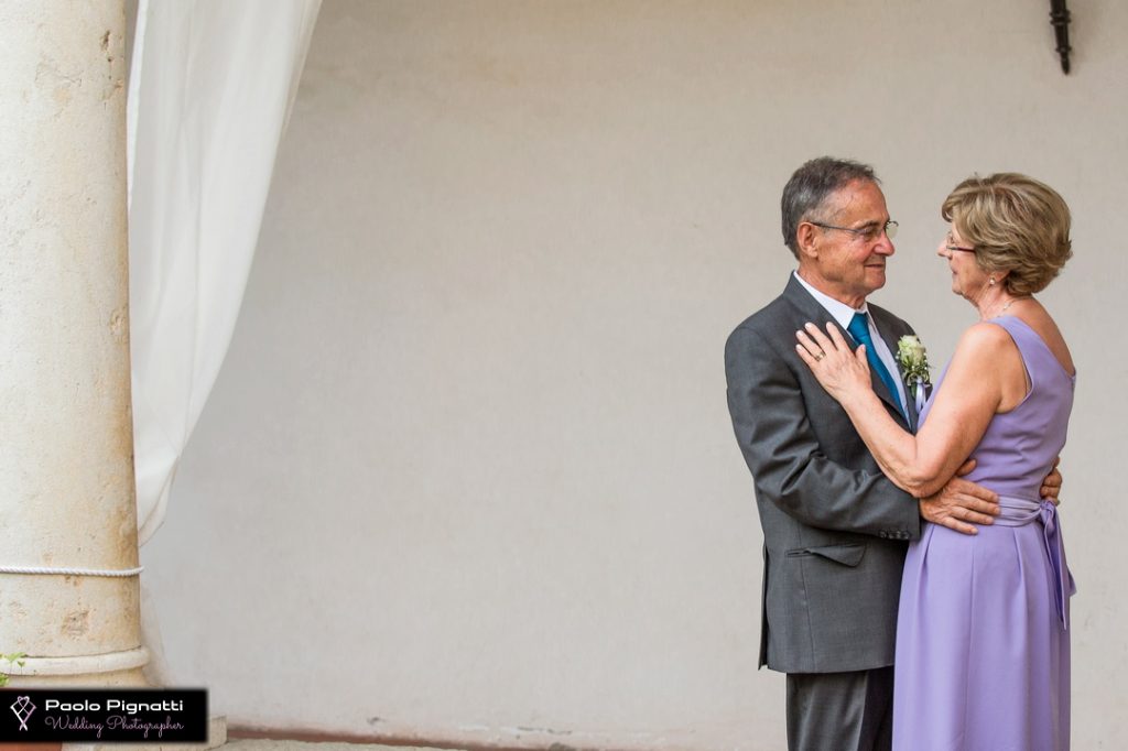 Coppia genitori che si abbraccia durante matrimonio figlio