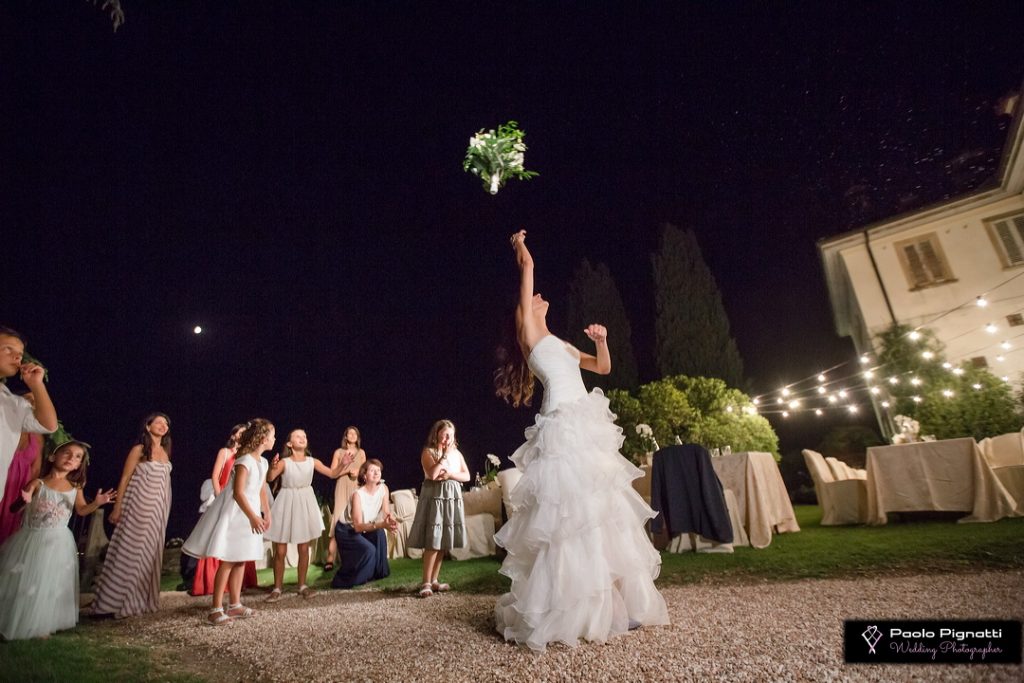 Sposa che lancia il bouquet di sera